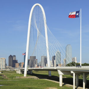 Dallas, Texas, USA - May 10, 2018:  Daytime view of the Margaret Hunt Hill bridge & the Dallas skyline. The Margaret Hunt Hill Bridge - named for the Dallas philanthropist -  was designed by Santiago Calatrava as part of the Trinity river bridge project. It parallels an older bridge - now used by pedestrians only.